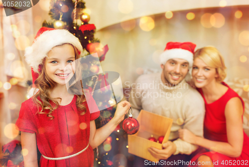 Image of smiling family decorating christmas tree