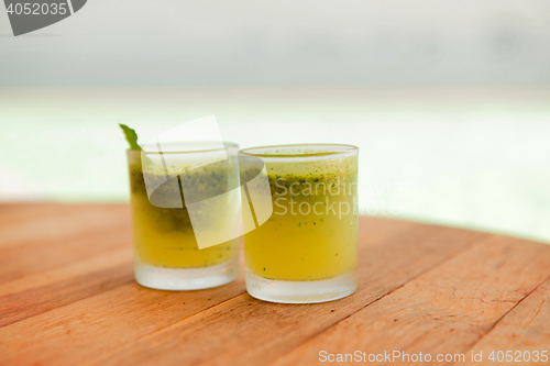 Image of glasses of fresh juice or cocktail on beach