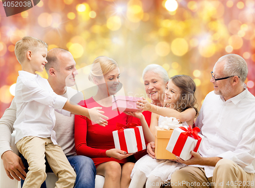 Image of happy family with christmas gifts over lights