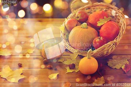 Image of close up of pumpkins in basket on wooden table