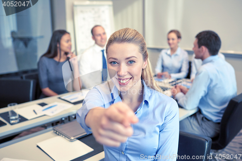 Image of group of smiling businesspeople meeting in office
