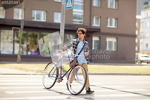 Image of young man with fixed gear bicycle on crosswalk