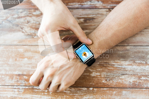 Image of close up of hands with music player on smart watch