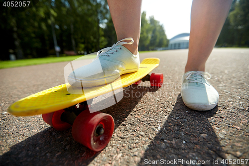 Image of close up of female feet riding short skateboard