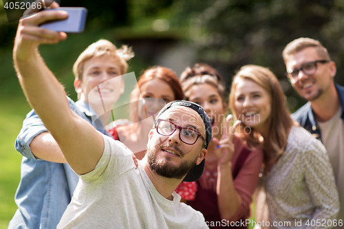 Image of friends taking selfie by smartphone at summer