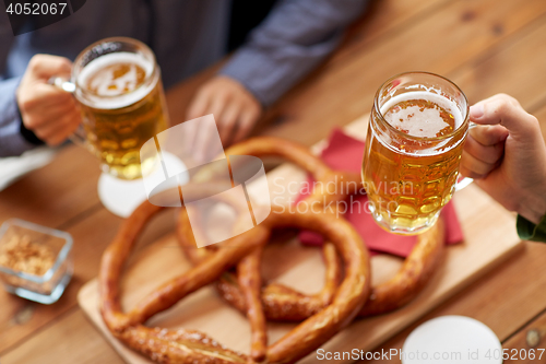 Image of close up of hands with beer mugs at bar or pub