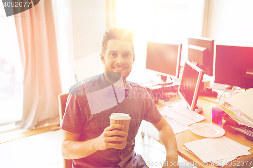 Image of happy creative male office worker drinking coffee
