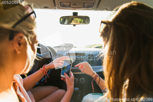 Image of teenage girls or women with smartphone in car