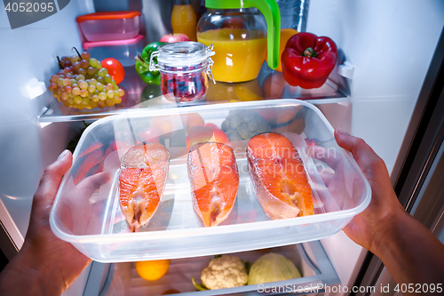 Image of Raw Salmon steak in the open refrigerator