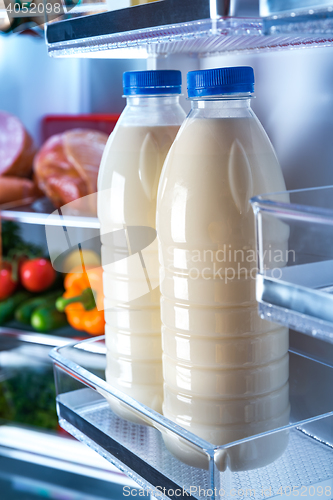 Image of Bottles of milk in the fridge