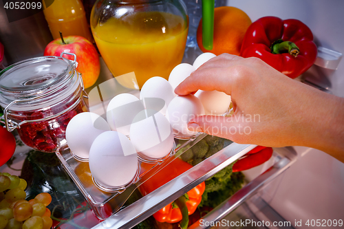 Image of Chicken eggs on a shelf open refrigerator