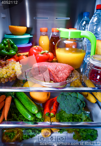 Image of Fresh raw meat on a shelf open refrigerator