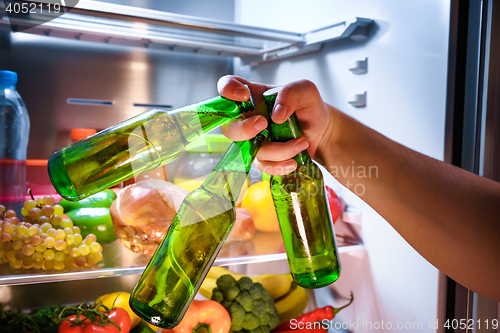 Image of Man taking beer from a fridge