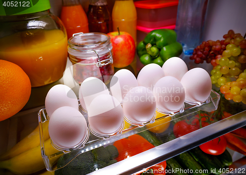 Image of Chicken eggs on a shelf open refrigerator