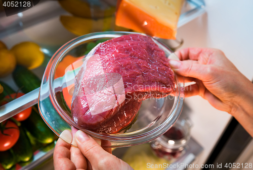 Image of Fresh raw meat on a shelf open refrigerator