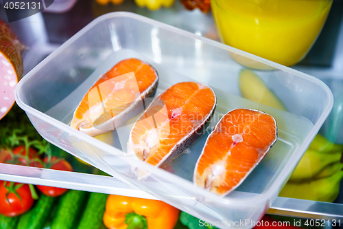 Image of Raw Salmon steak in the open refrigerator