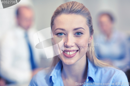 Image of group of smiling businesspeople meeting in office