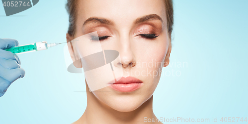 Image of woman face and hand with syringe making injection