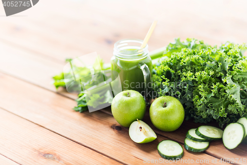 Image of close up of jug with green juice and vegetables