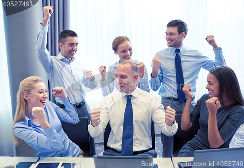 Image of business people celebrating victory in office