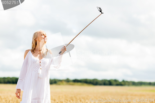 Image of happy young woman taking selfie by smartphone