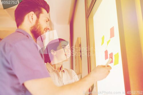 Image of creative team with stickers on glass at office