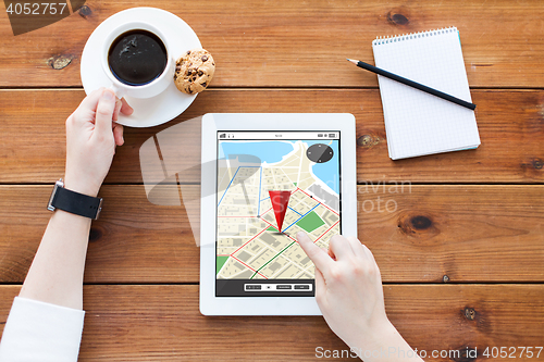 Image of close up of woman with tablet pc on wooden table