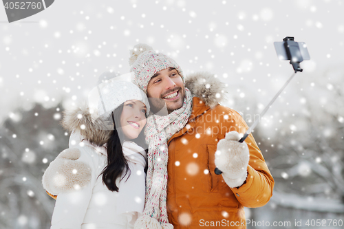 Image of happy couple taking selfie by smartphone in winter