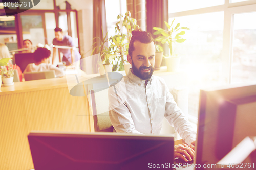 Image of happy creative male office worker with computer