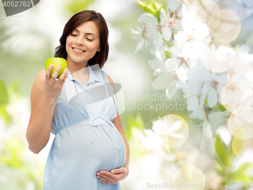 Image of happy pregnant woman looking at green apple