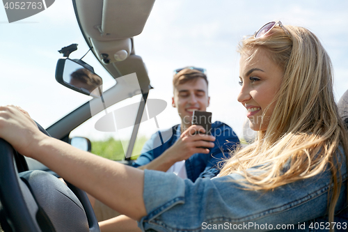 Image of man photographing woman driving car by smartphone