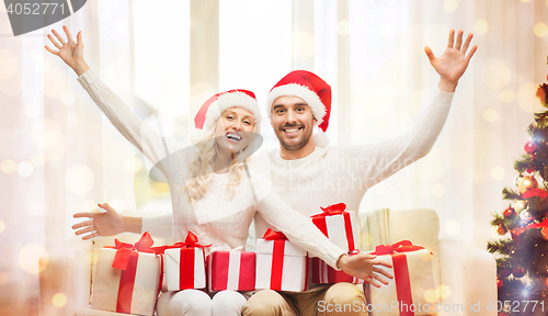 Image of happy couple at home with christmas gift boxes