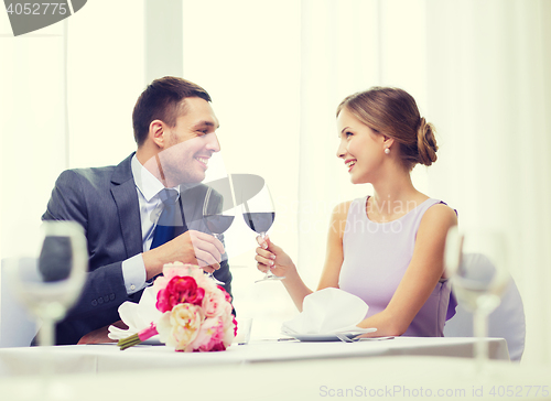 Image of young couple with glasses of wine at restaurant