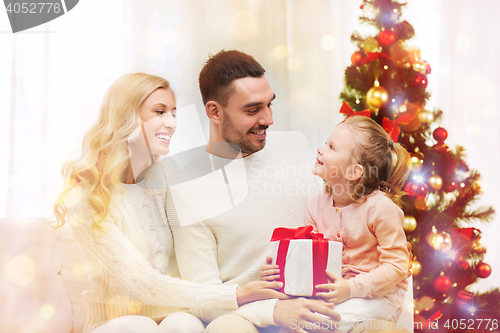 Image of happy family at home with christmas tree