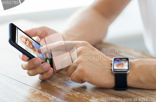 Image of close up of hands with smart phone and watch