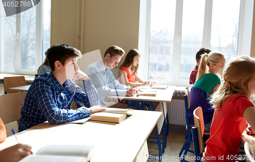 Image of group of students with books writing school test