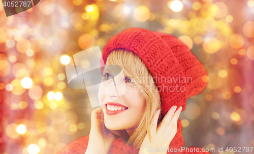 Image of happy woman in winter hat and scarf over lights