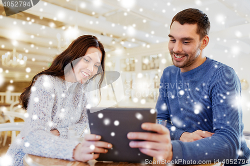 Image of happy couple with tablet pc drinking tea at cafe