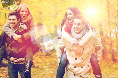 Image of smiling friends having fun in autumn park