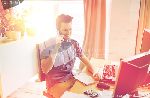 Image of happy creative male worker calling on smarphone