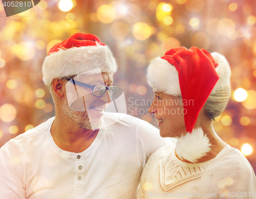 Image of happy senior couple in santa helper hats