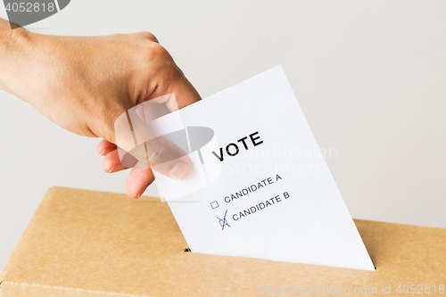 Image of man putting his vote into ballot box on election