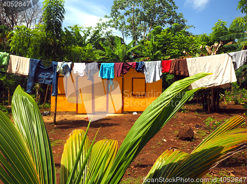 Image of zinc sheet metal house  jungle with laundry drying Quinn Hill Bi