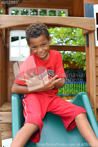 Image of editorial young Nicaraguan boy playing on slide Big Corn Island 