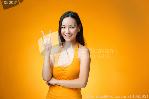 Image of The happy Chinese girl on yellow background
