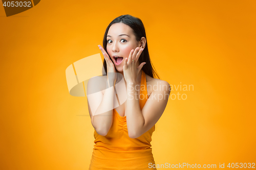 Image of The surprised Chinese girl on yellow background