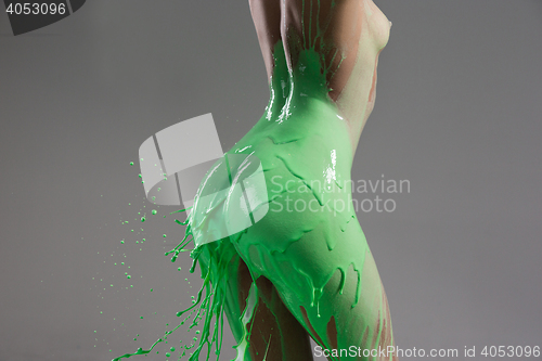 Image of The beautiful woman with green liquid paint over her body