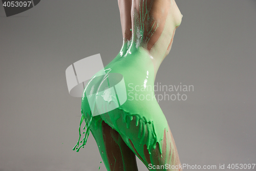 Image of The beautiful woman with green liquid paint over her body