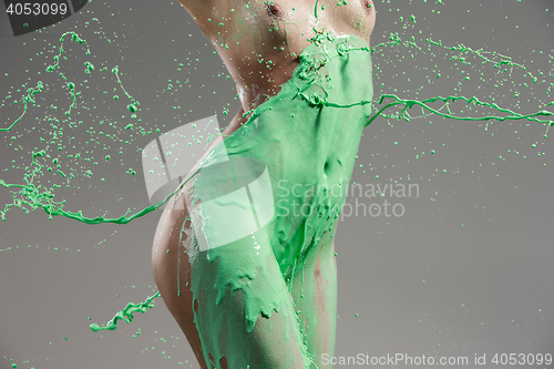 Image of The beautiful woman with green liquid paint over her body