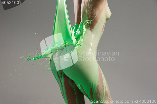 Image of The beautiful woman with green liquid paint over her body